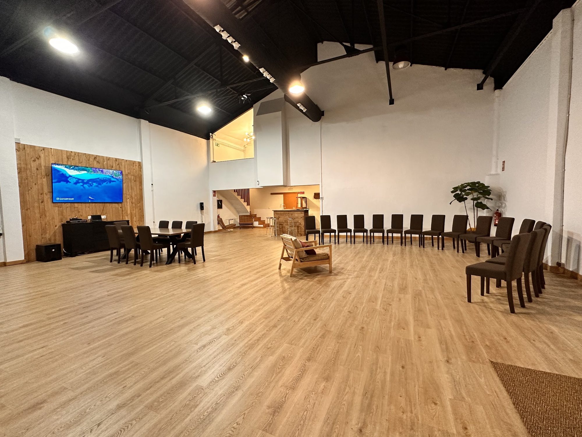 Sala principal vacía con paredes blancas y suelo de madera
